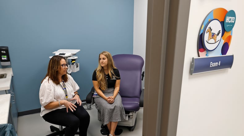 Anita Biles, from Springfield City Schools, left, and Amanda Ambrosio, from the Rocking Horse Center, discuss the success of The Health Center at Springfield High School Thursday, Sept. 26, 2024. BILL LACKEY/STAFF