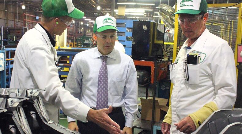 U.S. Rep. Jim Jordan, R-Urbana (center) listens as KTH Parts Industries vice president, Chris Millice (left) and senior vice president, Rob Hayes explains some of the parts the company makes. JEFF GUERINI/STAFF