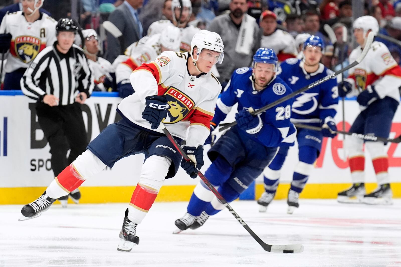 Florida Panthers center Anton Lundell (15) breaks out ahead of Tampa Bay Lightning center Zemgus Girgensons (28) during the third period in Game 1 of an NHL hockey Stanley Cup first-round playoff series, Tuesday, April 22, 2025, in Tampa, Fla. (AP Photo/Chris O'Meara)