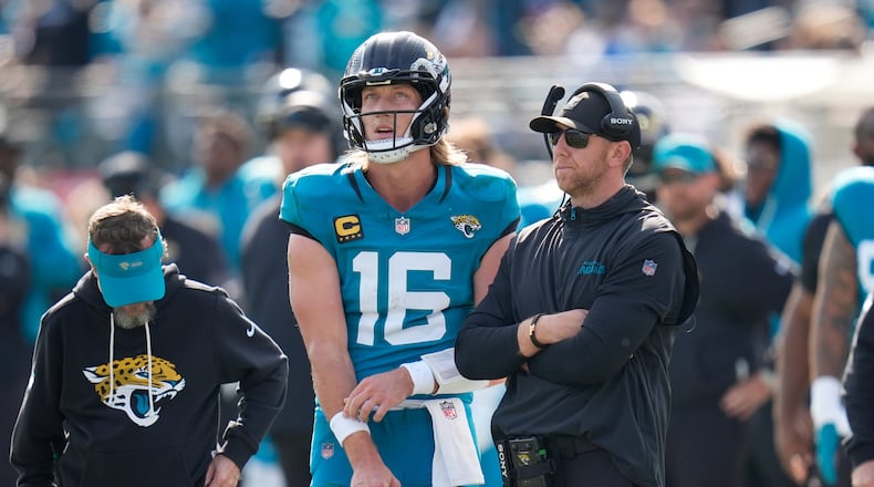 Jacksonville Jaguars quarterback Trevor Lawrence (16) stands next to head coach Liam Coen during the first half of an NFL wild-card playoff football game against the Buffalo Bills Sunday, Jan. 11, 2026, in Jacksonville, Fla. (AP Photo/John Raoux)