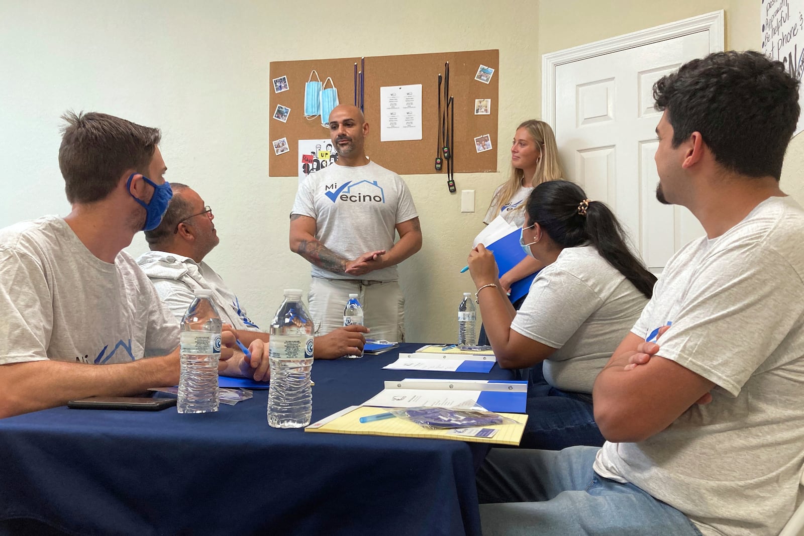 FILE - Alex Berrios, left, and Devon Murphy-Anderson, right, co-founders of the nonprofit Mi Vecino, coach newly hired staff members on how best to approach people and convince them to register to vote on June 24, 2021, in Kissimmee, Fla. (AP Photo/Will Weissert, File)