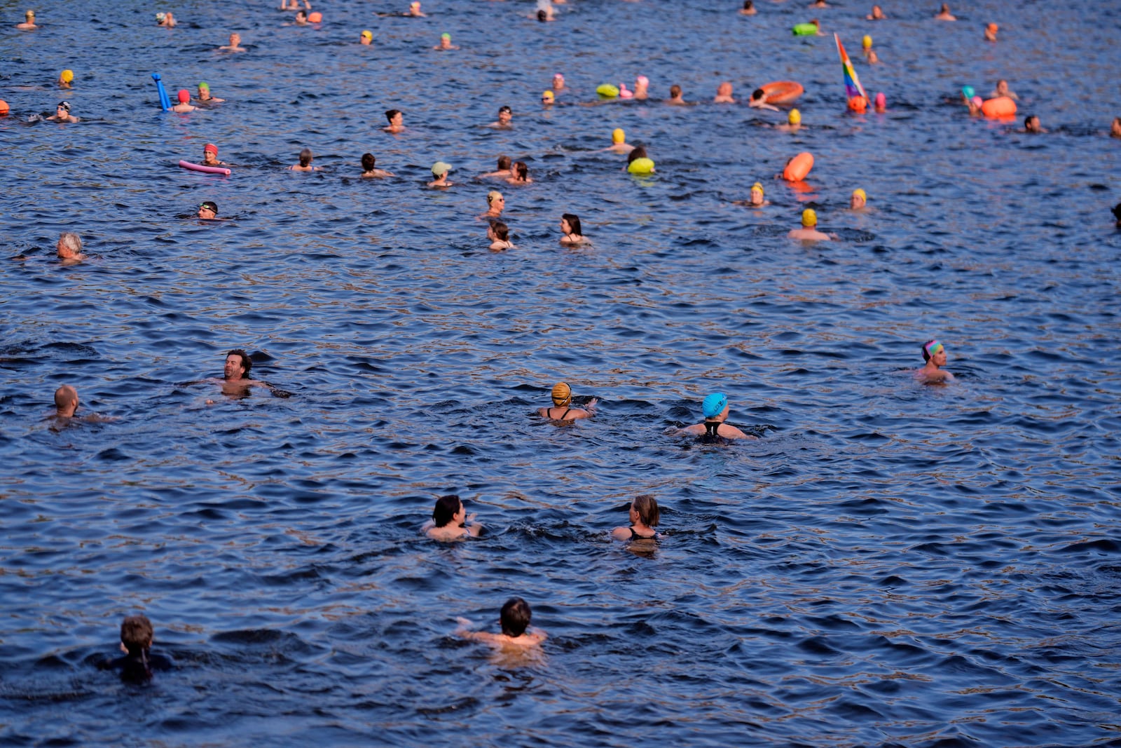 People swim in the river Spree to demand the lift of the hundred years old swimming ban at the river in Berlin, Germany, Tuesday, June 17, 2025. (AP Photo/Markus Schreiber)