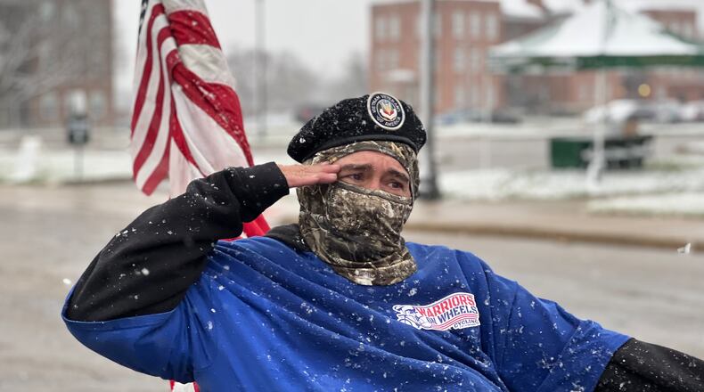 A veteran and parade participant salutes fellow vets in attendance during Saturday's event at the Dayton VA Medical Center campus. AIMEE HANCOCK/STAFF