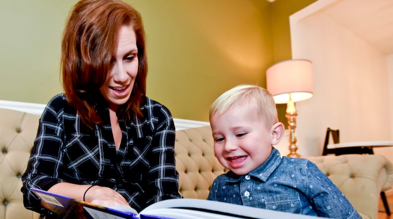 Sara Flynn reads a book from the Dolly Parton Imagination Library to her son Theo at her home in Middletown. The program is expanding to include Clark County. NICK GRAHAM/STAFF