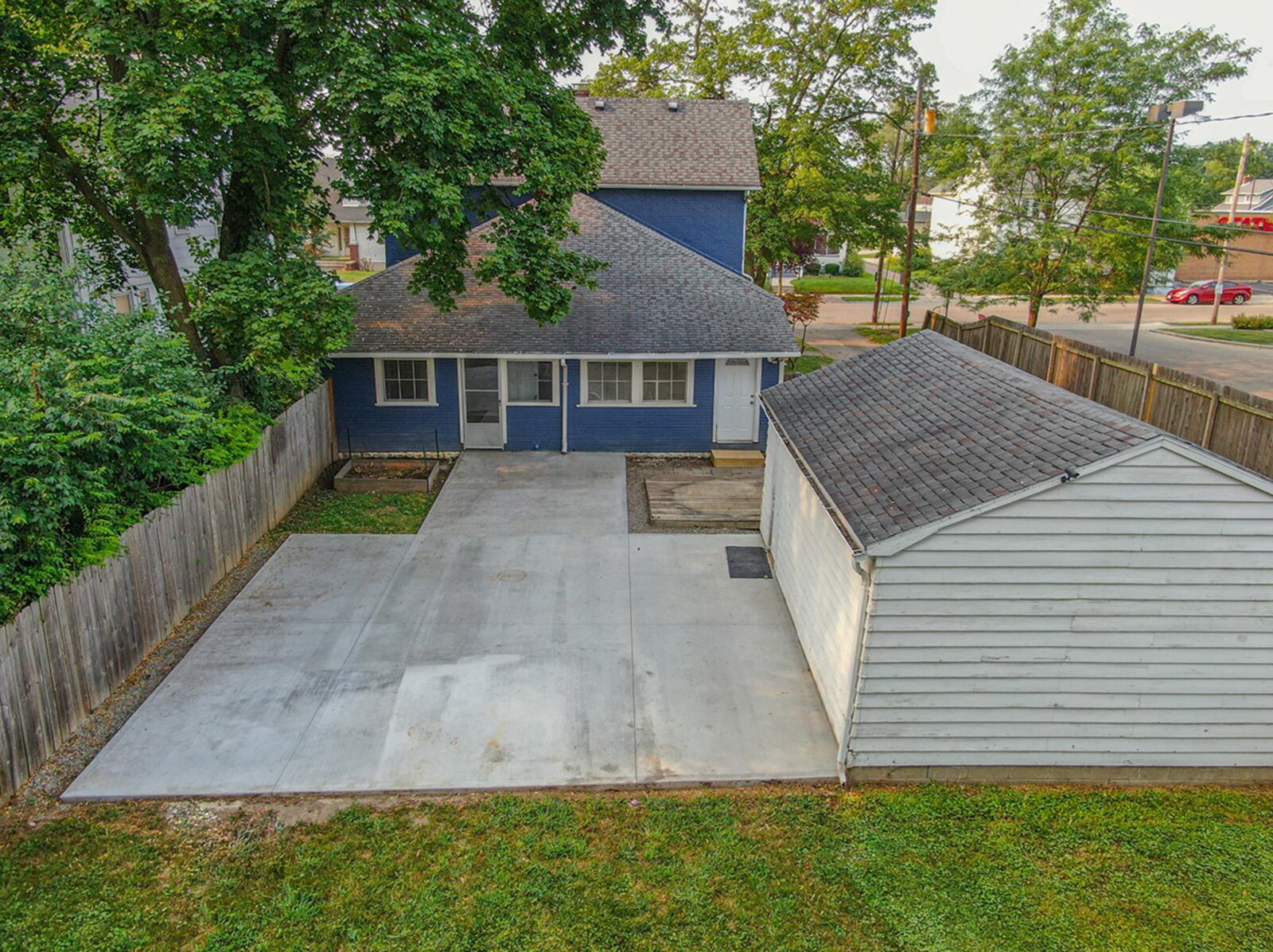 The back features a full privacy fence, concrete and paver patio with wood deck, firepit in grassy area and mature trees. CONTRIBUTED PHOTO
