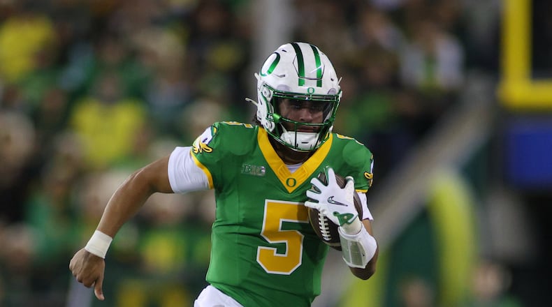 Oregon quarterback Dante Moore (5) runs the ball during the first half of an NCAA college football game against Minnesota Friday, Nov. 14, 2025, in Eugene, Ore. (AP Photo/Lydia Ely)