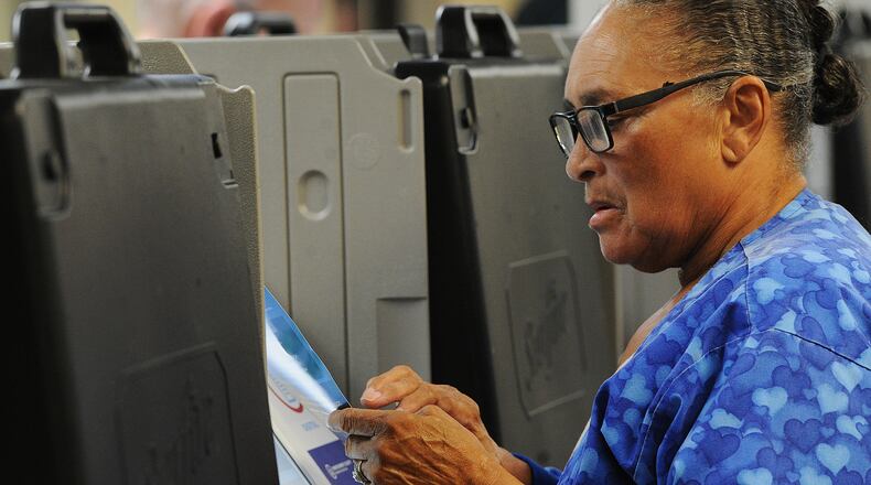 Alana Harrison checks over her ballot while voting Wednesday Oct. 12, 2022 at the Montgomery County Board of Elections. Early voting started Wednesday in Ohio. Election officials expect a large turnout of early voters this year. MARSHALL GORBY\STAFF