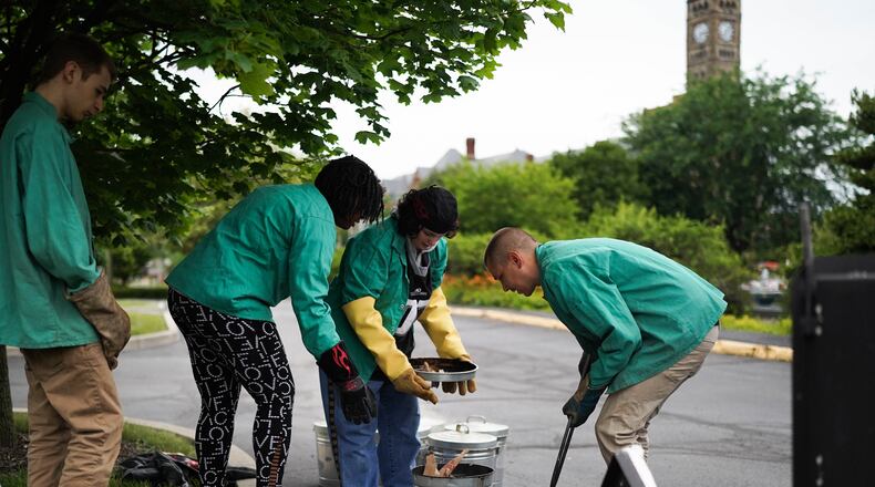 Geno Luketic, right, guides Project Jericho students as they take their Raku creations out of a kiln as part of the annual Summer Arts Camp.