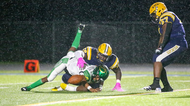Springfield High School senior Tywan January sacks Northmont quarterback Cahke' Cortner while senior teammate Jokell Brown celebrates during their game on Friday, Oct. 29 in Springfield. Michael Cooper/CONTRIBUTED