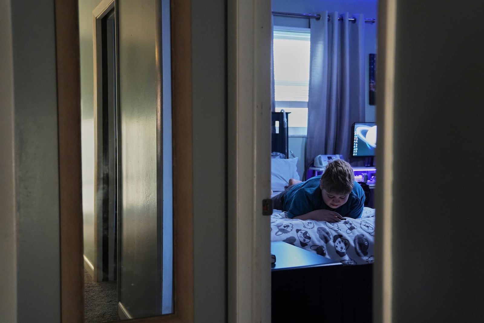 Julian Blazier relaxes in his bedroom Tuesday, April 8, 2025, in Bloomfield, Ind. (AP Photo/Joshua A. Bickel)