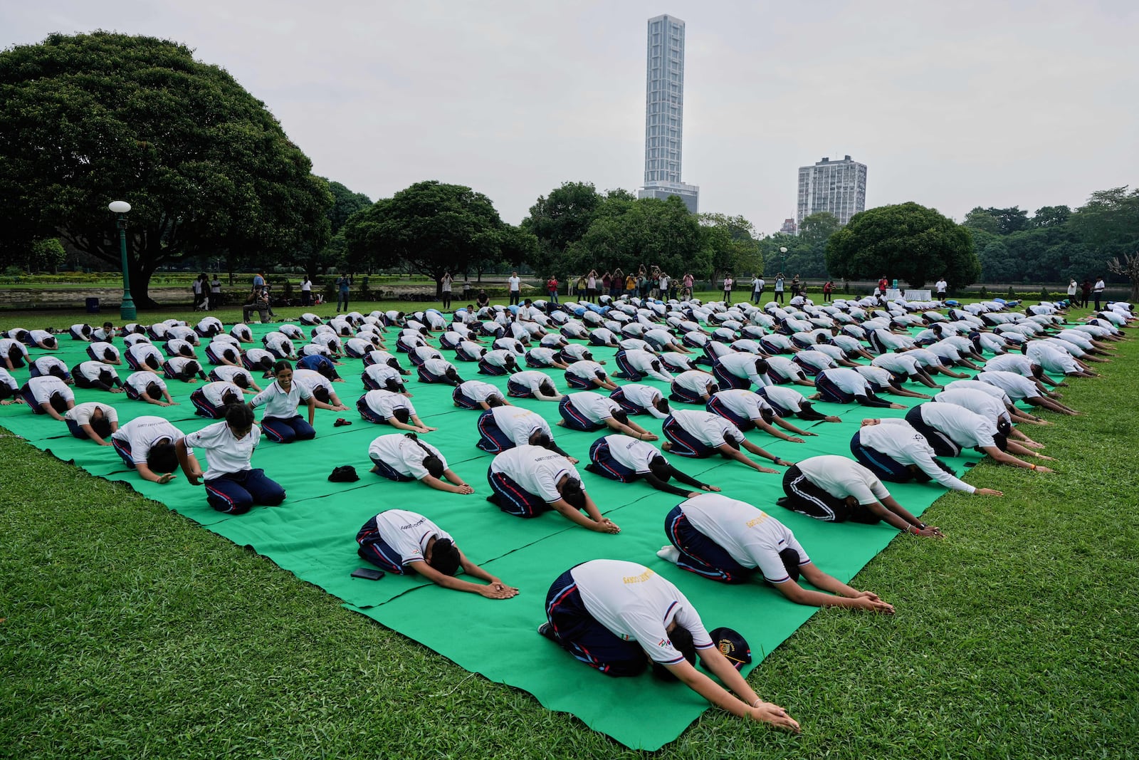 School boys and girls perform yoga on International Yoga Day at Victoria Memorial compound, in Kolkata, India, Saturday, June 21, 2025. (AP Photo/Bikas Das)