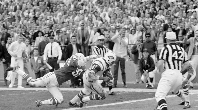 FILE - New York Jets fullback Matt Snell ,center, runs the ball as Baltimore linebacker Dennis Gaubatz, left, defends during the NFL football Super Bowl 3 in Miami, Jan. 12, 1969. (AP Photo, File)
