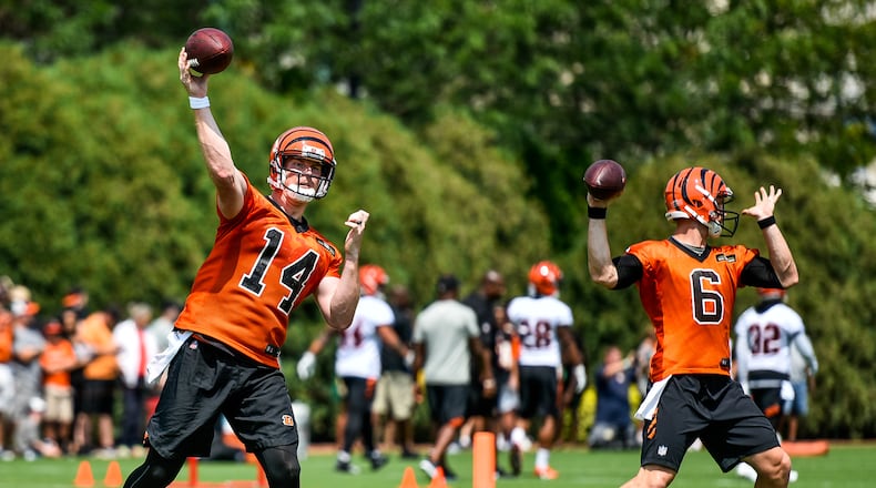 Quarterbacks Andy Dalton (14) and Jeff Driskel (6) pass the ballduring the first day of Cincinnati Bengals Training Camp Friday, July 28 at the practice fields beside Paul Brown Stadium in Cincinnati. NICK GRAHAM/STAFF