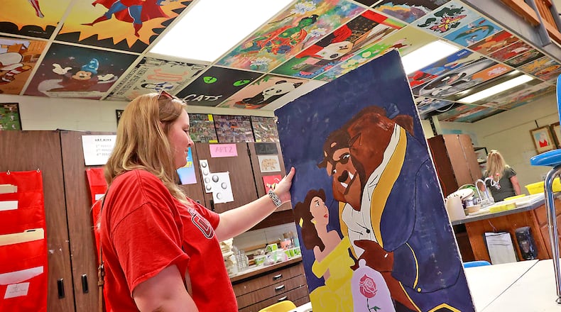 Makayla Noble, a 2019 graduate of Kenton Ridge High School, looks at the art room ceiling tile that her mother painted before she graduated from the school in 1992 during the "One Last Look" open house Tuesday, May 9, 2023. The community was invited to tour Kenton Ridge High School as well as Northridge Middle/Elementary School and Rolling Hill Elementary School to reminisce before the school buildings are closed at the end of the school year. Kenton Ridge schools will be moving to a new preschool - 12 school building in the fall. BILL LACKEY/STAFF