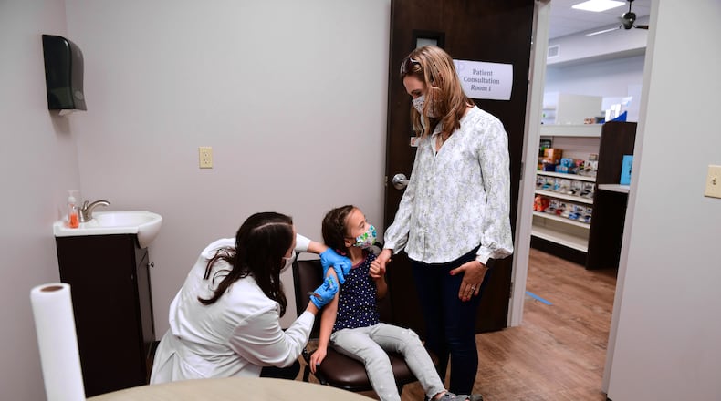 Katie Perry gives a vaccine to a child at Cedar Care Pharmacy in Cedarville. CONTRIBUTED