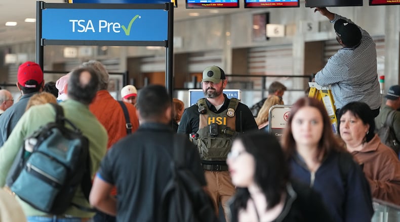 A federal officer, stands at a Transportation Security Administration (TSA) checkpoint at Philadelphia International Airport in Philadelphia, Friday, March 27, 2026. (AP Photo/Matt Rourke)