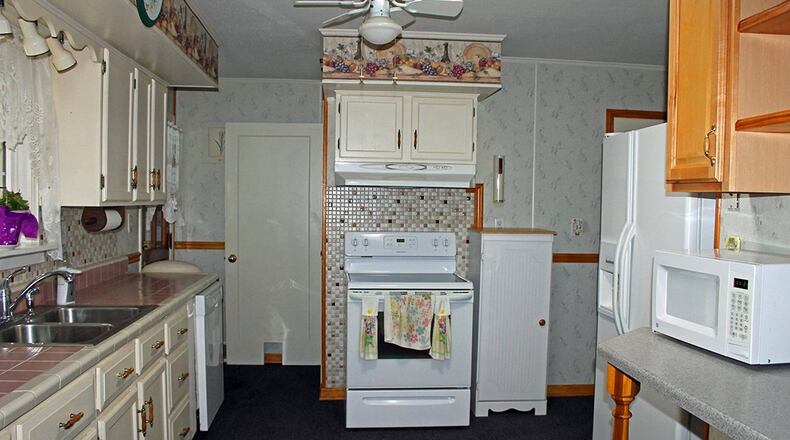 Features of the bright kitchen include plenty of crisp, white cabinetry. A window over the sink looks out on the backyard.