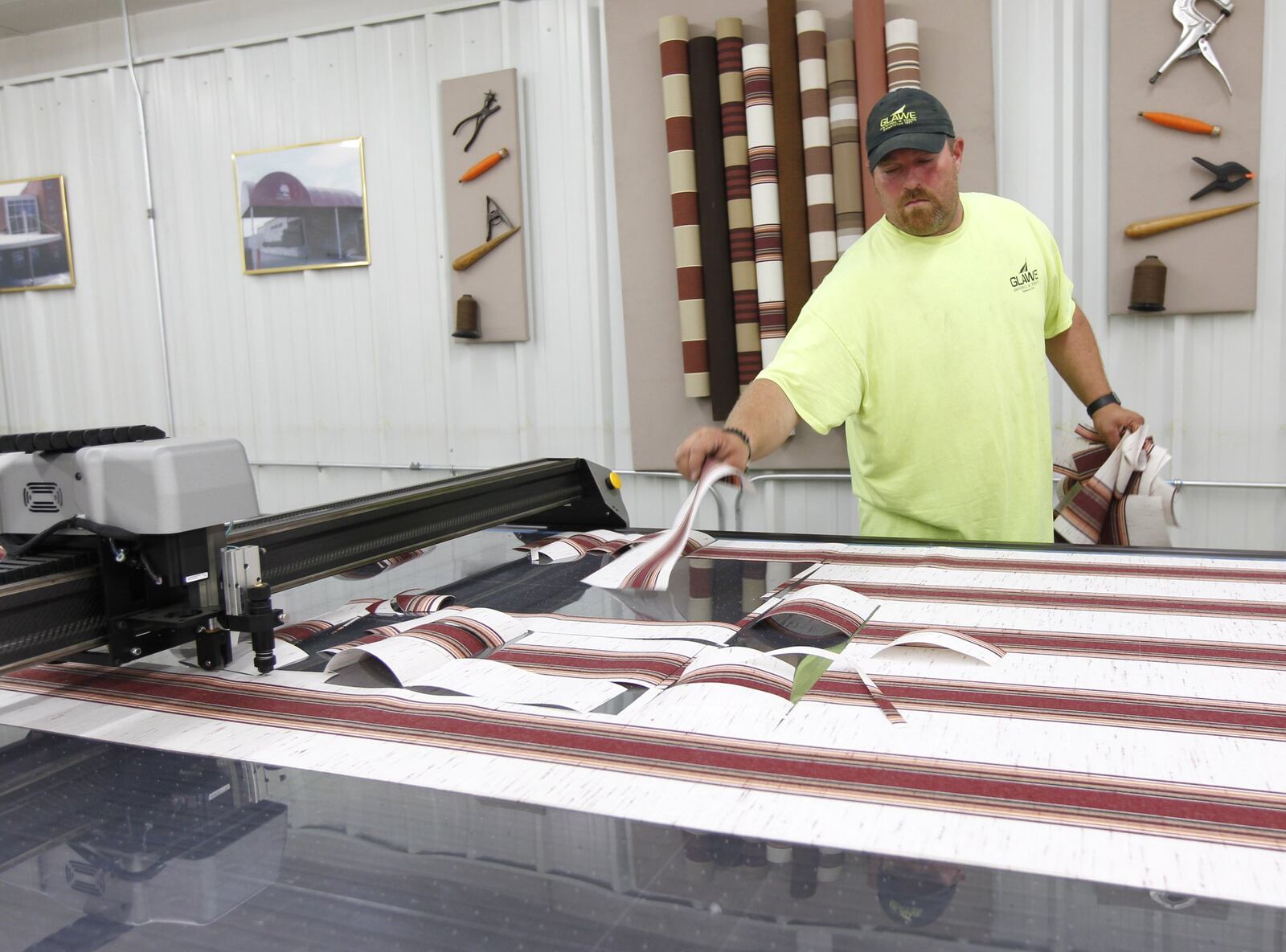 Shaun Fridley, grandson of Glawe’s CEO Vernon Schaefer, operates a digital fabric cutter that saves hours of manual cutting time for custom awnings and tents. TY GREENLEES / STAFF