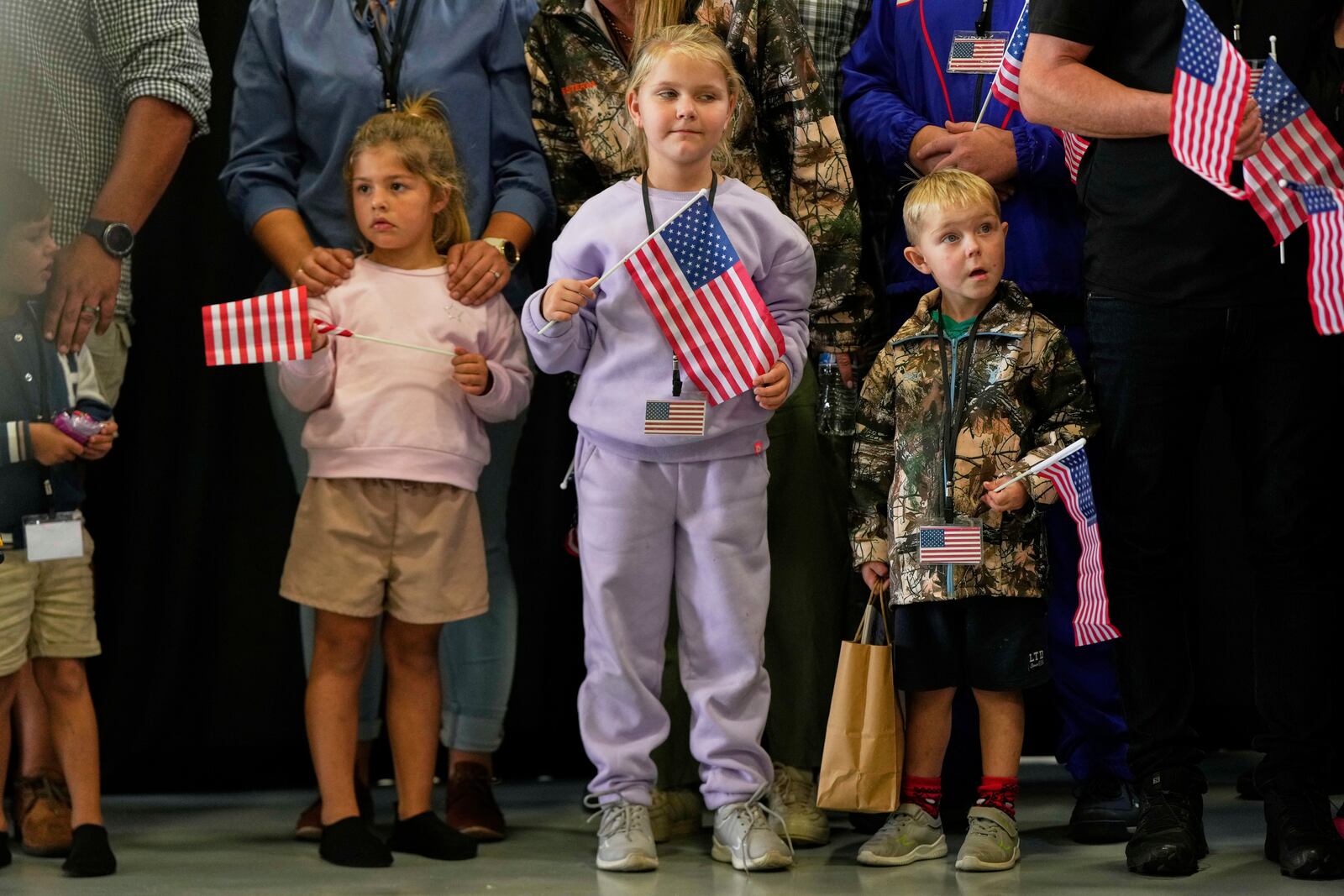 Young Afrikaner refugees from South Africa holding American flags arrive, Monday, May 12, 2025, at Dulles International Airport in Dulles, Va. (AP Photo/Julia Demaree Nikhinson)