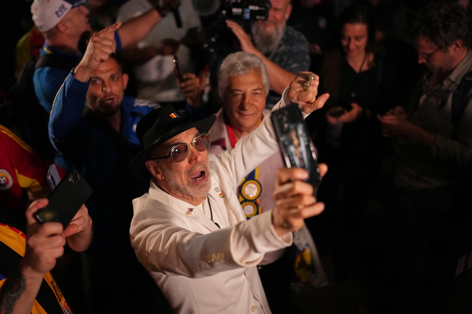 Supporters of Presidential candidate George Simion react to the exit poll results during the first round of the country's presidential election redo in Bucharest, Romania, Sunday, May 4, 2025. (AP Photo/Andreea Alexandru)