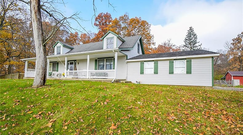 The Cape Cod-style home with 3 bedrooms and a finished, walk-out basement is set on more than 32 mostly wooded acres. The home has a full, covered front porch with railings and a concrete walk that leads to the 2-car, attached garage. CONTRIBUTED PHOTO