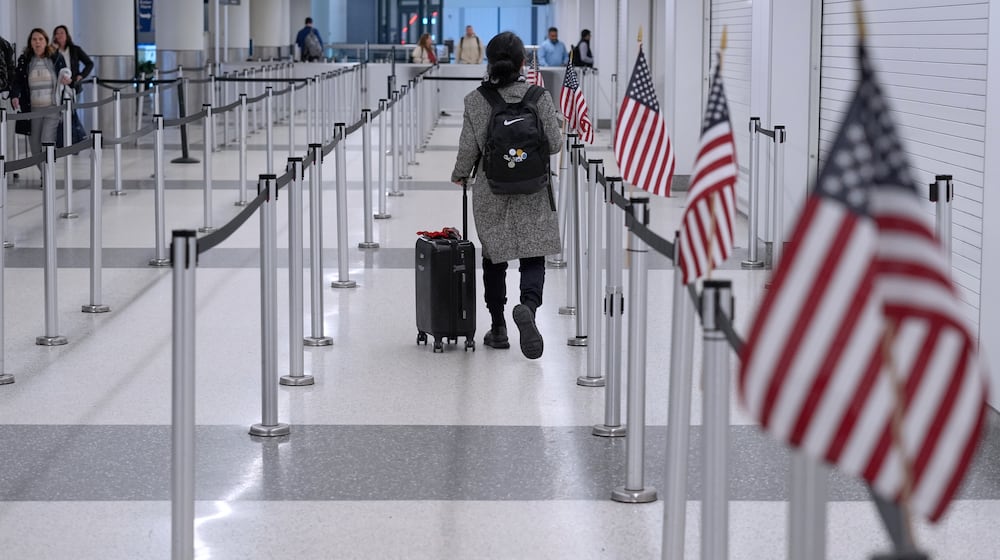 A traveler walks through a TSA security checkpoint in Terminal B, Friday, March 27, 2026, at Logan International Airport in Boston. (AP Photo/Robert F. Bukaty)