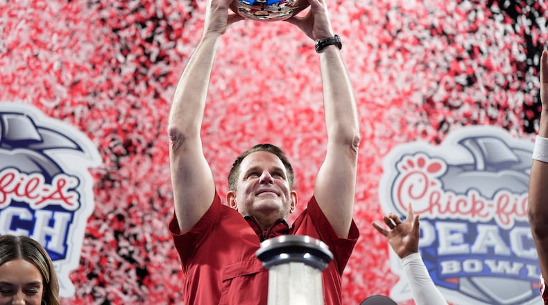 Indiana head coach Curt Cignetti holds up the trophy after the Peach Bowl NCAA college football playoff semifinal against Oregon, Friday, Jan. 9, 2026, in Atlanta. (AP Photo/Brynn Anderson)