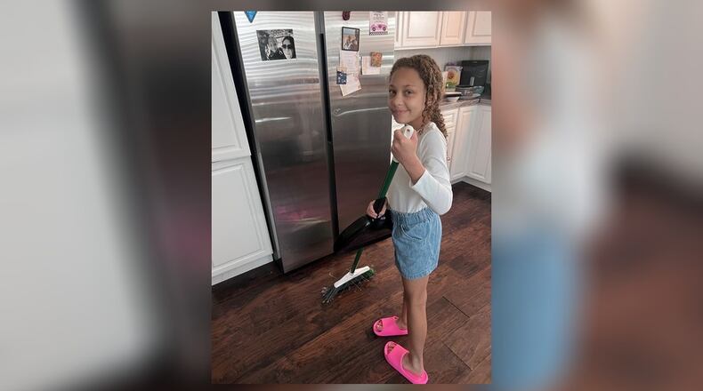 Pamela's daughter helping to sweep the kitchen during their spring clean. CONTRIBUTED