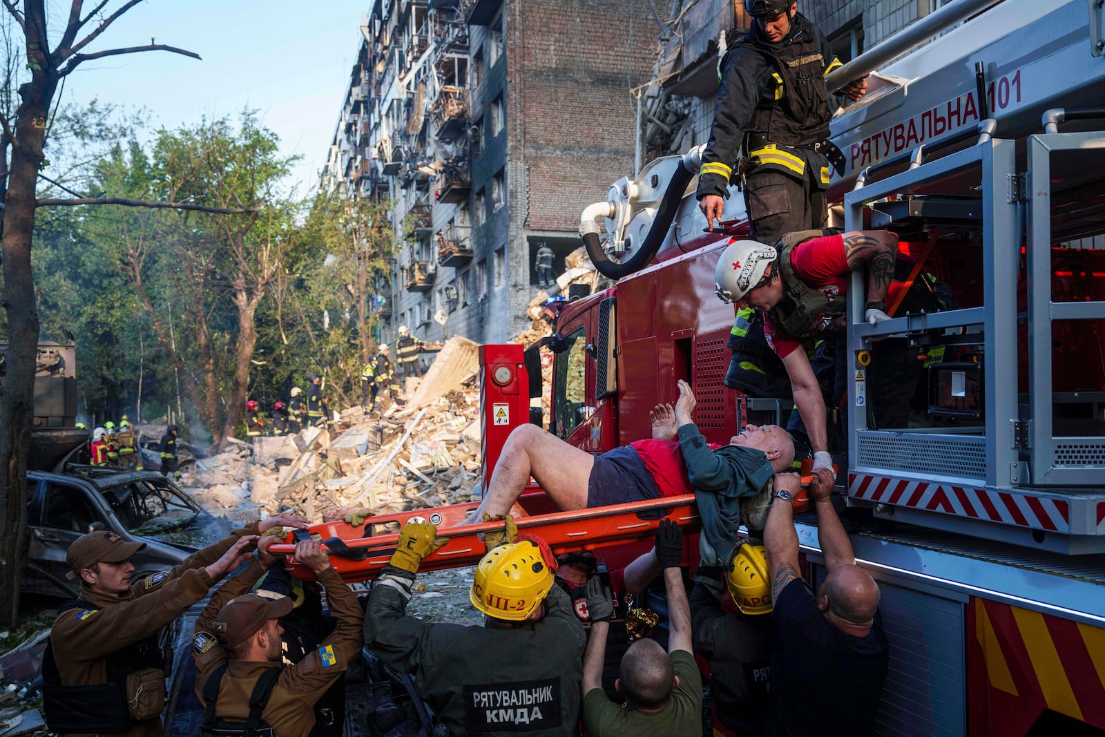 Rescue workers evacuates an injured man from a multi-storey residential house destroyed by a Russian strike in Kyiv, Ukraine, on Tuesday, June 17, 2025. (AP Photo/Evgeniy Maloletka)