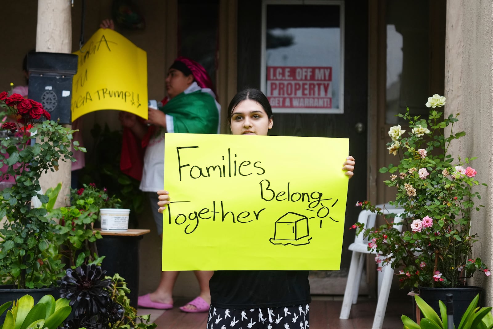 FILE - A resident holds a sign while protesting ICE presence and detentions on June 21, 2025, in Pasadena, Calif. (AP Photo/Damian Dovarganes, file)