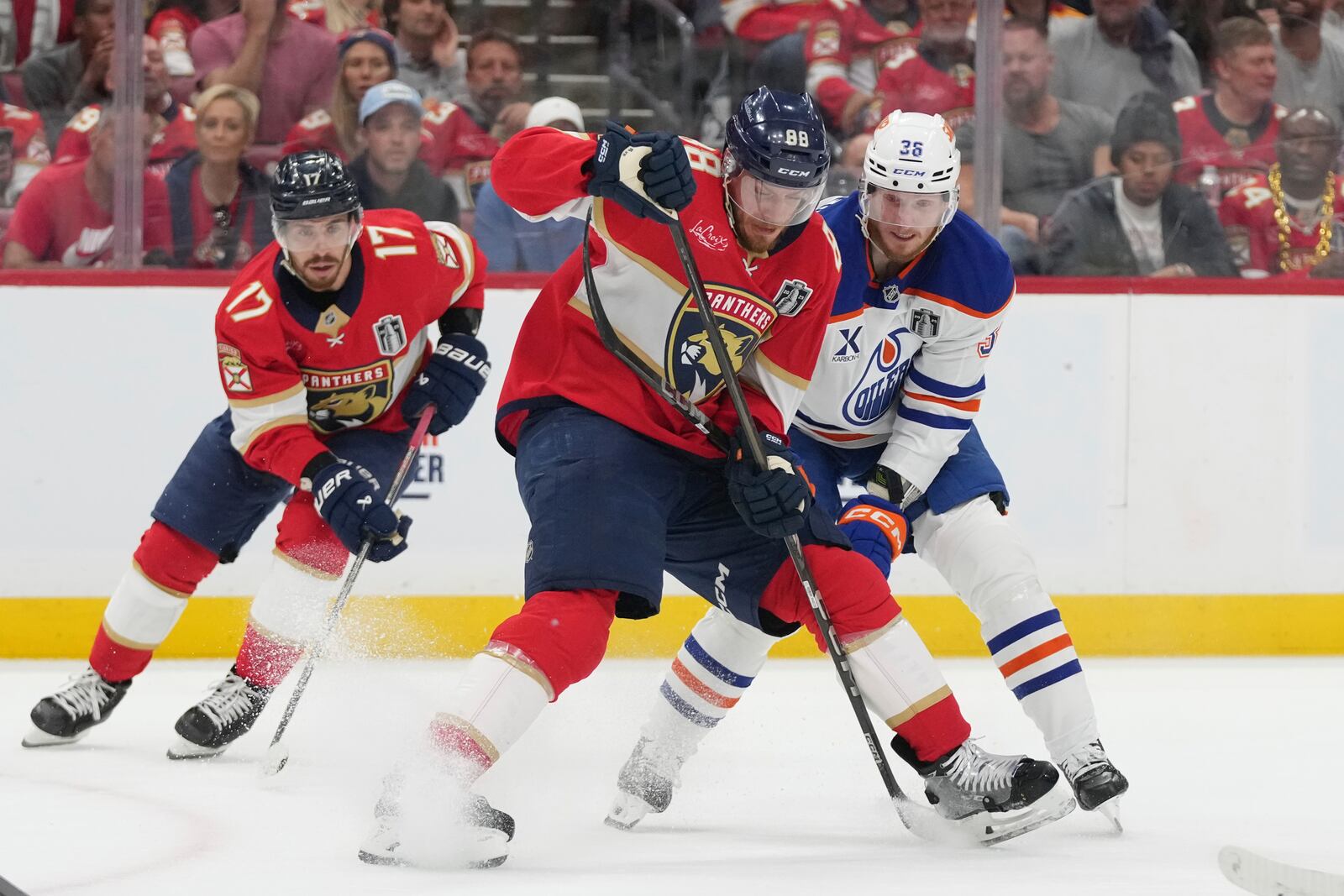 Florida Panthers defenseman Nate Schmidt (88) and Edmonton Oilers defenseman John Klingberg (36) go after the puck during the first period of Game 6 of the NHL hockey Stanley Cup Final Tuesday, June 17, 2025, in Sunrise, Fla. (AP Photo/Lynne Sladky)