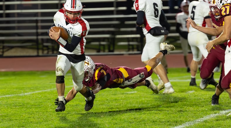 Triad High School freshman quarterback Ty Botkins runs past Northeastern senior Jackson Jones during their game on Friday, Oct. 24 at Conover Stadium. The Jets won 42-0 and clinched a share of the OHC North title with the victory. RODNEY GETZ / CONTRIBUTED PHOTO