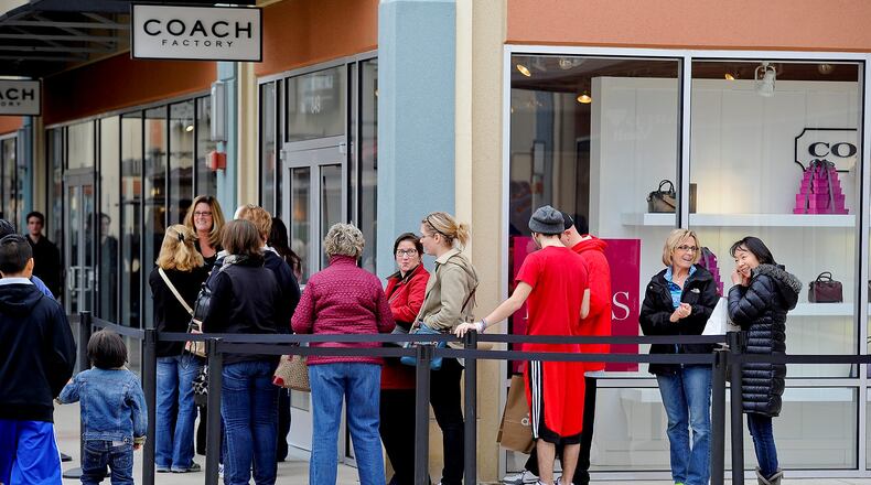 Shoppers looking for Black Friday deals wait outside the Coach store at Cincinnati Premium Outlets Friday, Nov. 27 in Monroe. NICK GRAHAM/STAFF