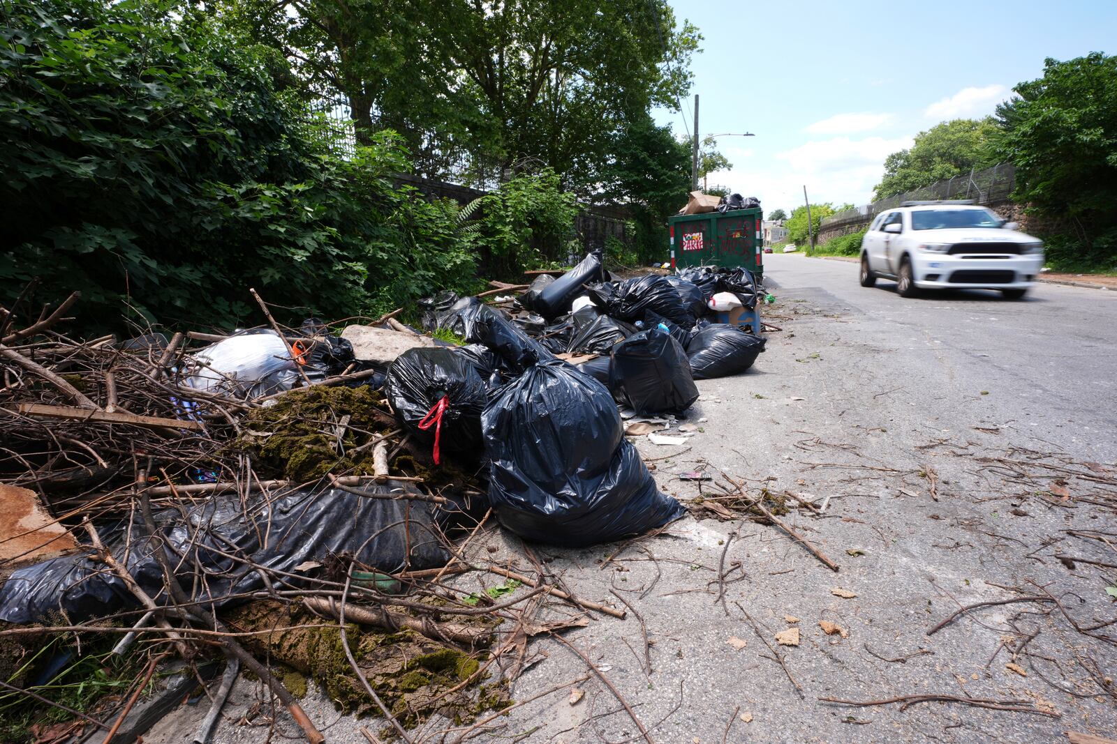 A car drives past a garbage collection site, Wednesday, July 9, 2025, in Philadelphia. (AP Photo/Matt Slocum)