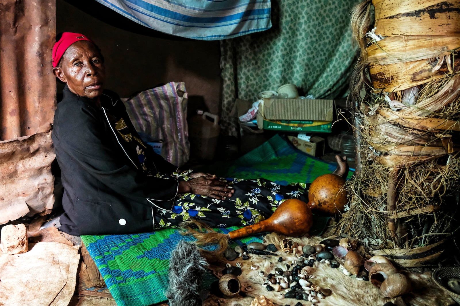 Traditional healer Rose Mukite poses for a photograph inside her igloo-shaped shrine during an interview with The Associated Press in Kampala, Uganda Monday, June 23, 2025. (AP Photo/Hajarah Nalwadda)