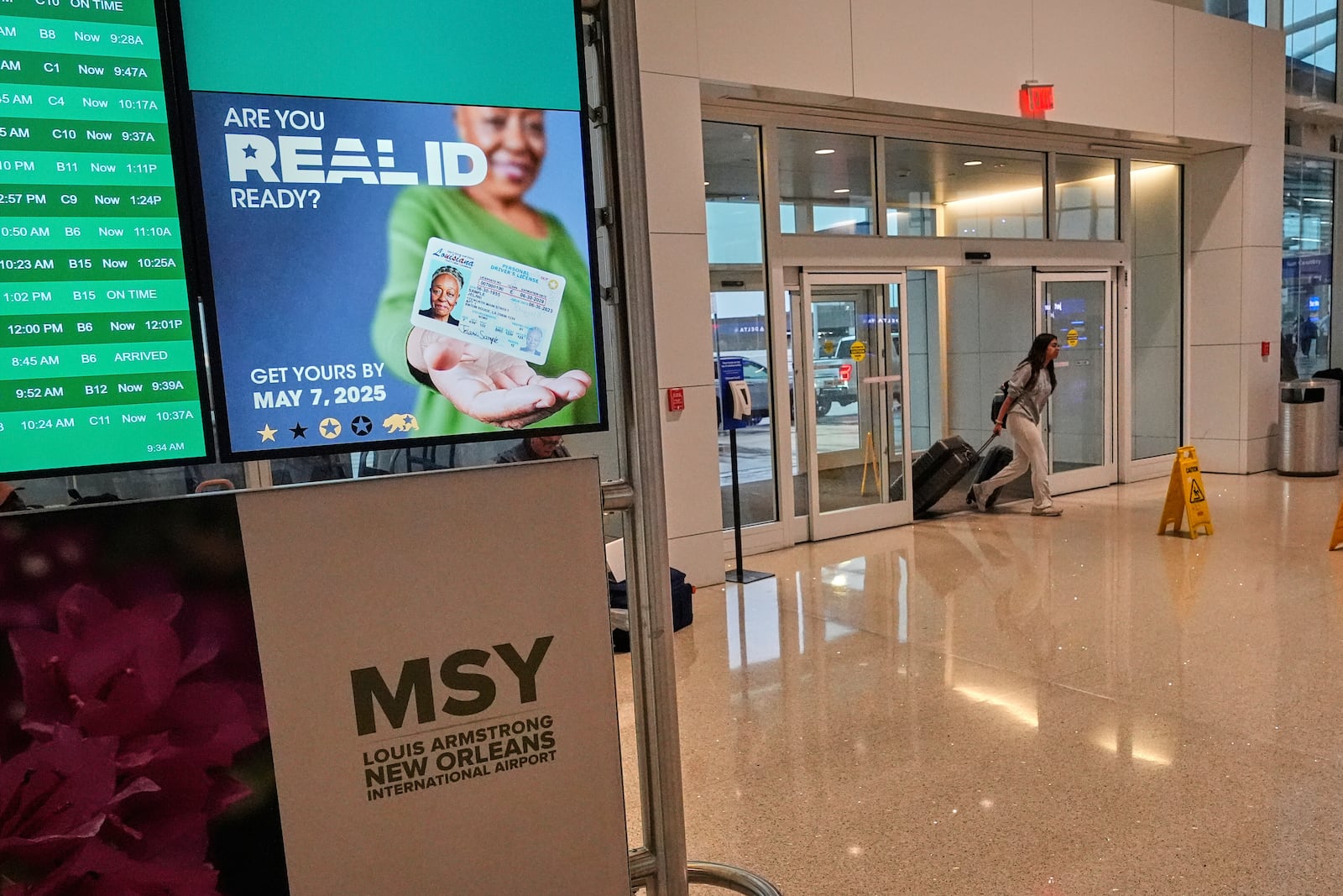 Signage reminds travelers of the new Real ID mandate at Louis Armstrong New Orleans International Airport in Kenner, La., the first day Real ID is implemented for commercial airline travel, Wednesday, May 7, 2025. (AP Photo/Gerald Herbert)
