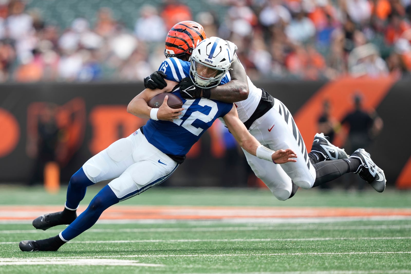 Indianapolis Colts quarterback Jason Bean (12) is sacked by Cincinnati Bengals' Isaiah Thomas during the second half of a preseason NFL football game, Saturday, Aug. 23, 2025, in Cincinnati. (AP Photo/Carolyn Kaster)