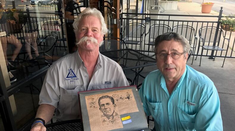 Kevin O Donnel (left) and Doug Spatz (right) with the treasured scrapbook of their great uncle Norb Sacksteder, one of the early superstars of the fledgling NFL and before that the pre-NFL pro game and the college game (including the University of Dayton). Tom Archdeacon/STAFF