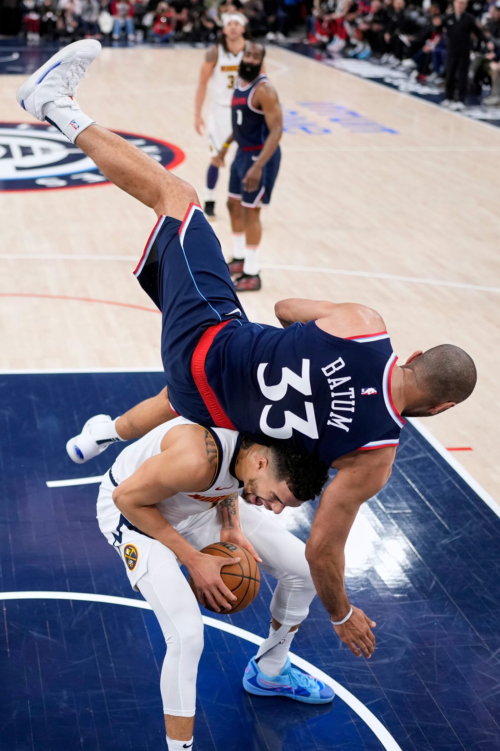 Los Angeles Clippers forward Nicolas Batum, top, falls over Denver Nuggets forward Michael Porter Jr., bottom, during the first half in Game 4 of an NBA basketball first-round playoff series Saturday, April 26, 2025, in Inglewood, Calif. (AP Photo/Mark J. Terrill)