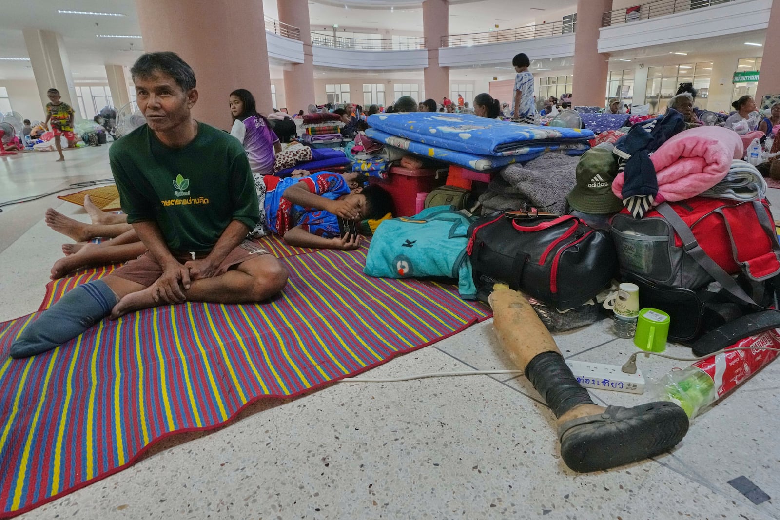 Thai residents who fled homes following the clashes between Thai and Cambodian soldiers, rest at an evacuation center in Surin province, Thailand, Wednesday, July 30, 2025. (AP Photo/Sakchai Lalit)