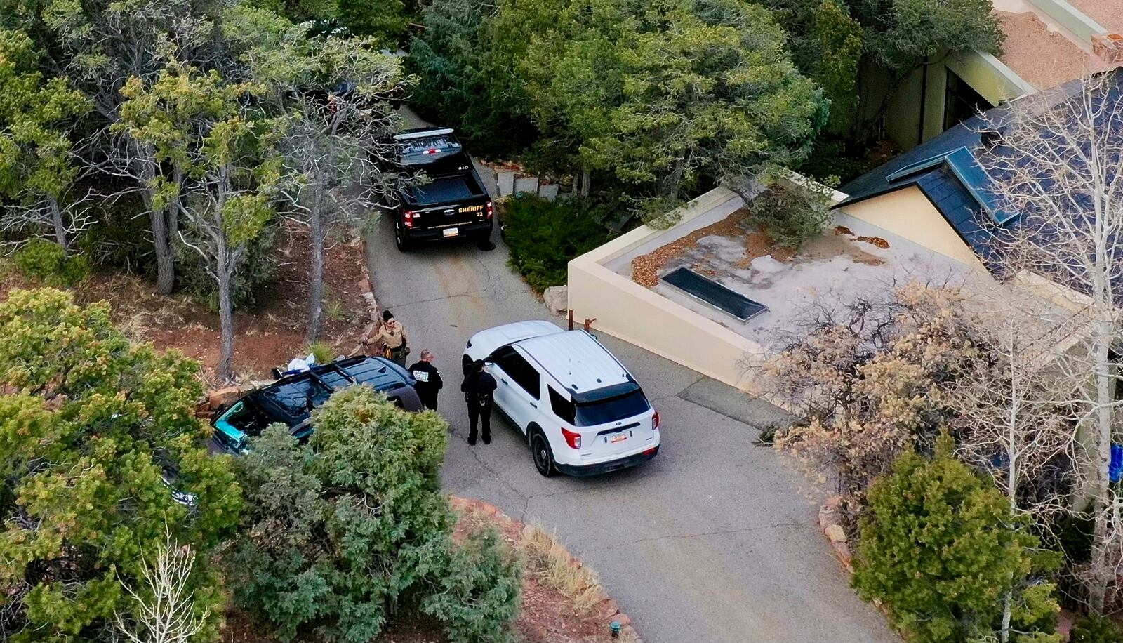 FILE - Law enforcement officials talk outside the home of actor Gene Hackman on Feb. 27, 2025 in Santa Fe, New Mexico. (AP Photo/Roberto Rosales, file)