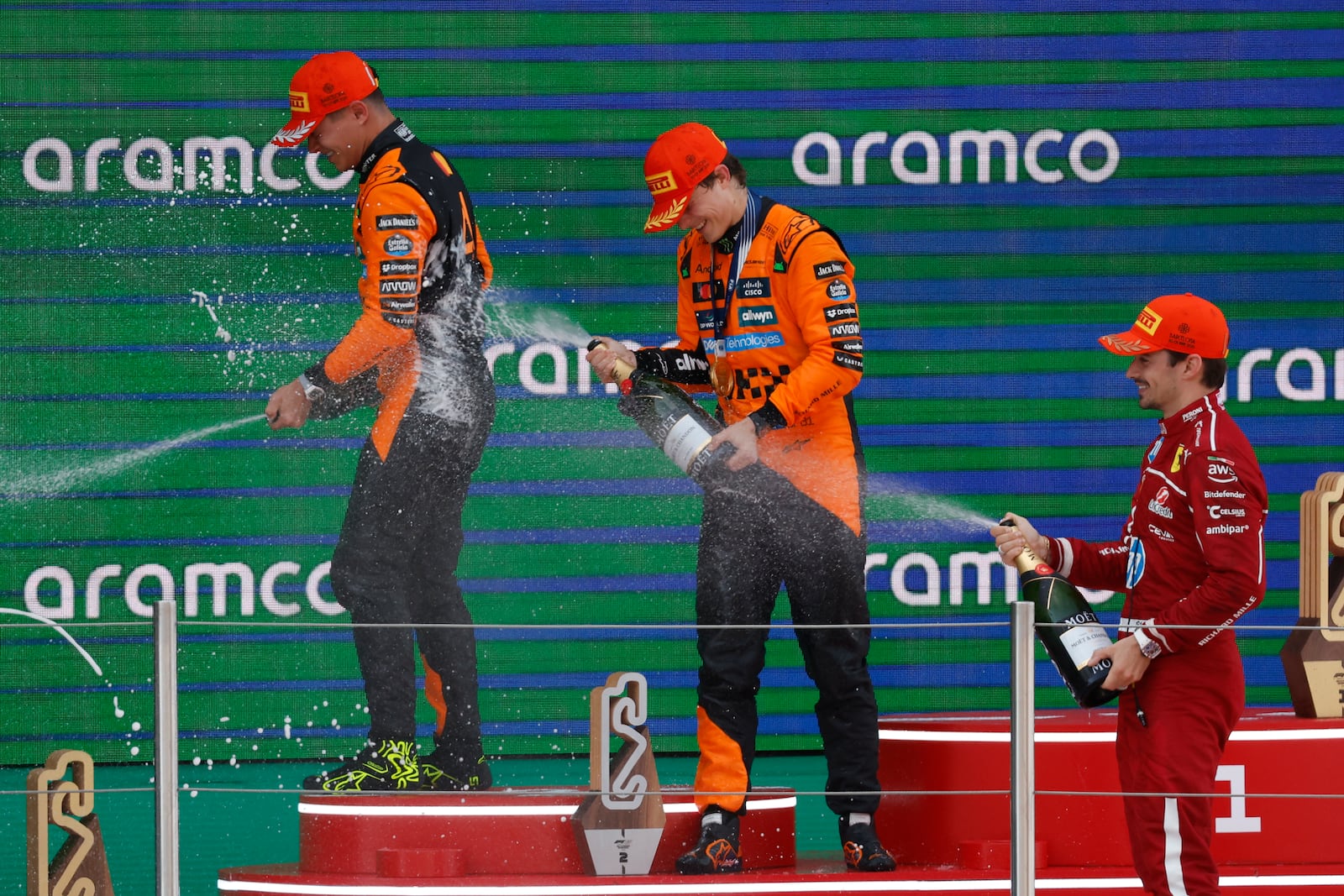 McLaren driver Oscar Piastri of Australia, center, celebrates on the podium with McLaren driver Lando Norris of Britain, left, and Ferrari driver Charles Leclerc of Monaco after winning the Spanish Grand Prix Formula One race at the Barcelona Catalunya racetrack in Montmelo, near Barcelona, Spain, Sunday, June 1, 2025. (AP Photo/Joan Monfort)