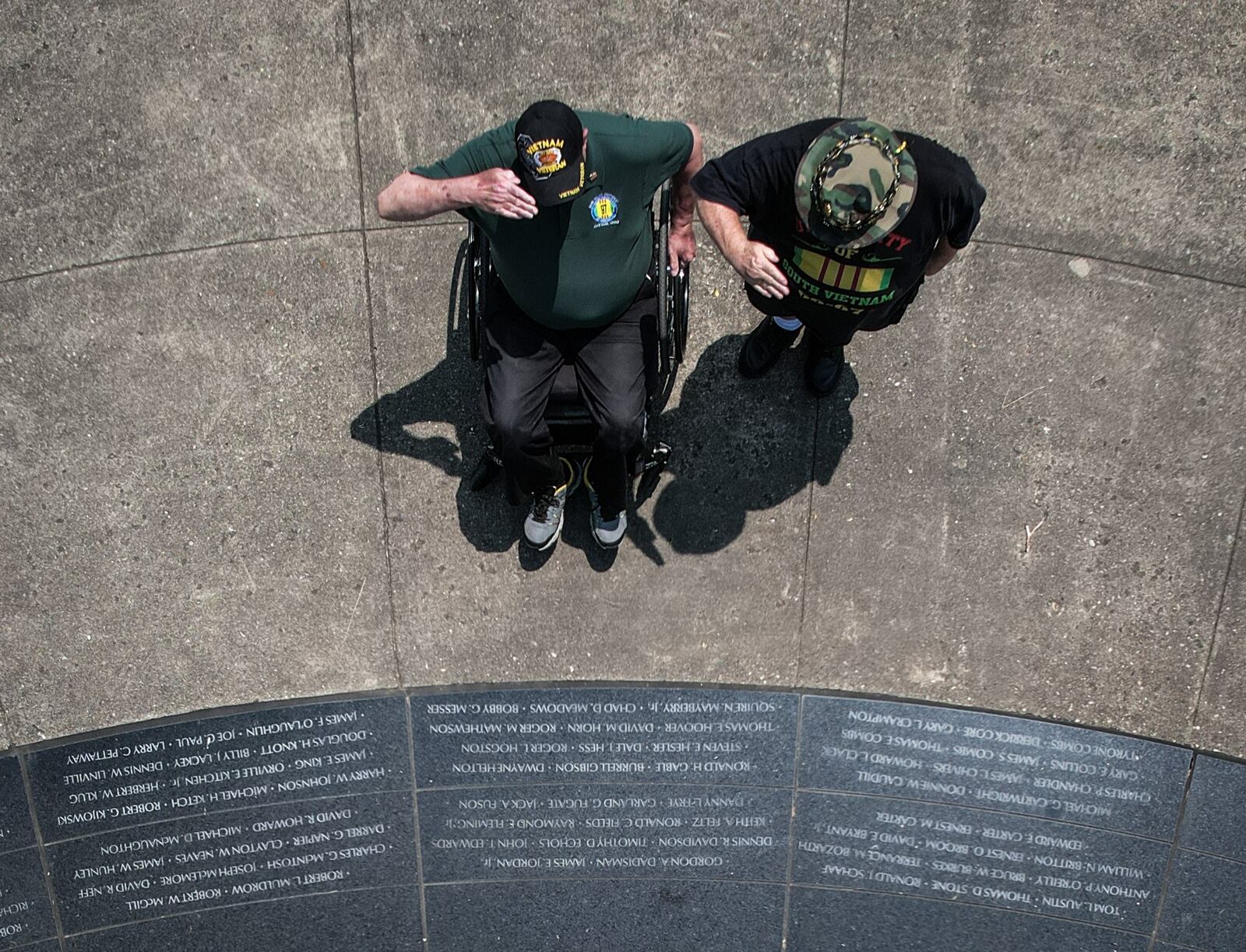 Vietnam veterans Michael Vanderveen left, and David Fuchs salute fallen soldiers at the Vietnam Veterans Memorial Park in Dayton Friday May 19, 2023. JIM NOELKER/STAFF