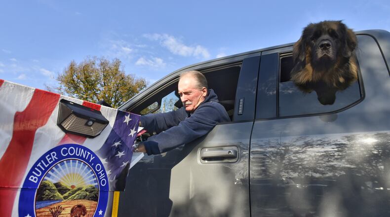 Jim Gau places his ballot in the drop box as his dog, Gunner, sticks his head out of the window at the Butler County Board of Elections Thursday, October 22, 2020 in Hamilton. NICK GRAHAM / STAFF