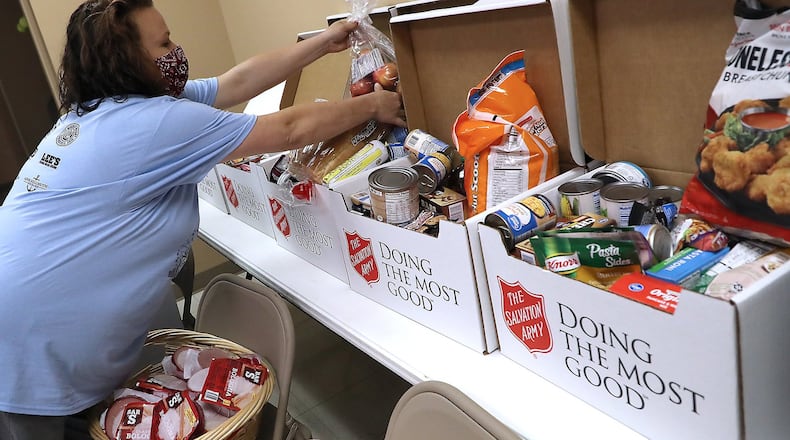 Nicole Hall fills up a food box in the Springfield Salvation Army’s food pantry Friday. BILL LACKEY/STAFF