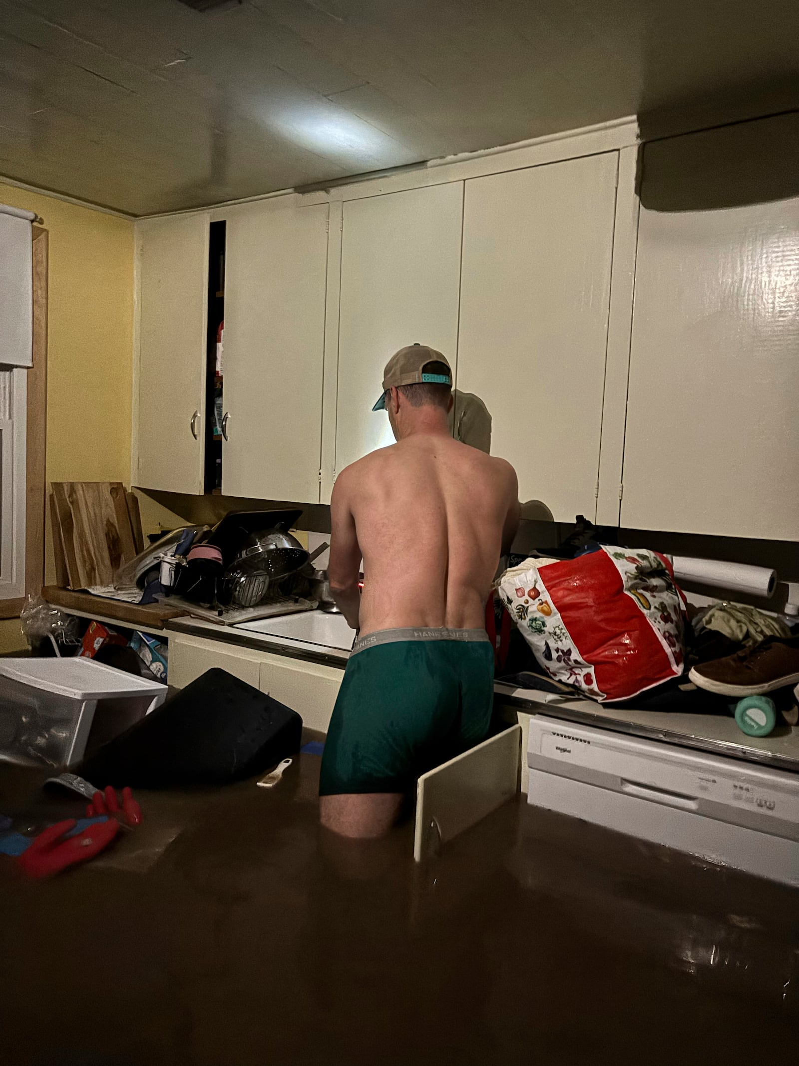 Alden Towler stands in the flooded kitchen of his cabin in Hunt, Texas, at 4:20 a.m. on Friday, July 4, 2025. (Shabd Simon-Alexander via AP)