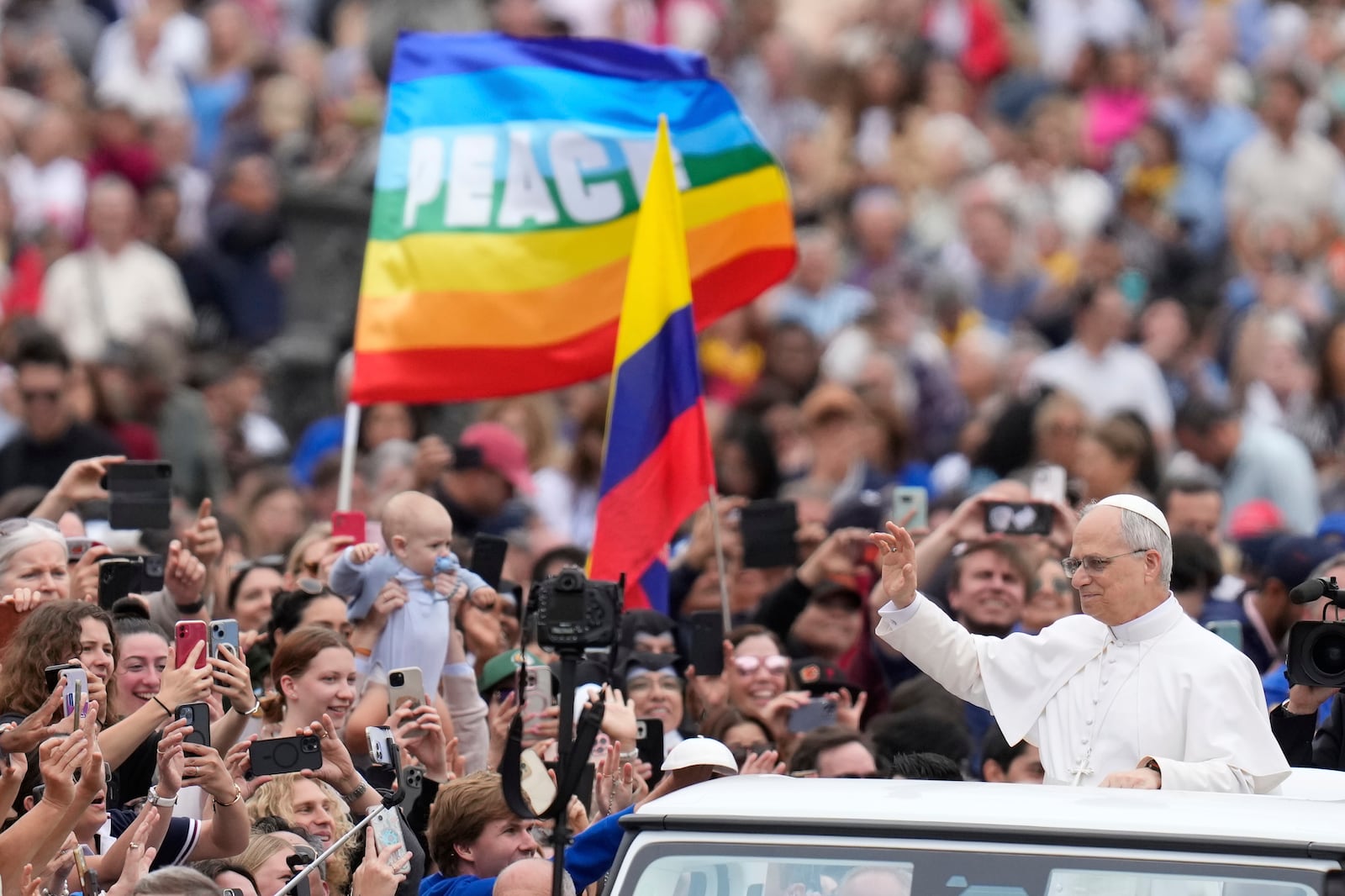 Pope Leo XIV waves as he arrives for his first weekly general audience in St. Peter's Square at The Vatican, Wednesday, May 21, 2025. (AP Photo/Gregorio Borgia)