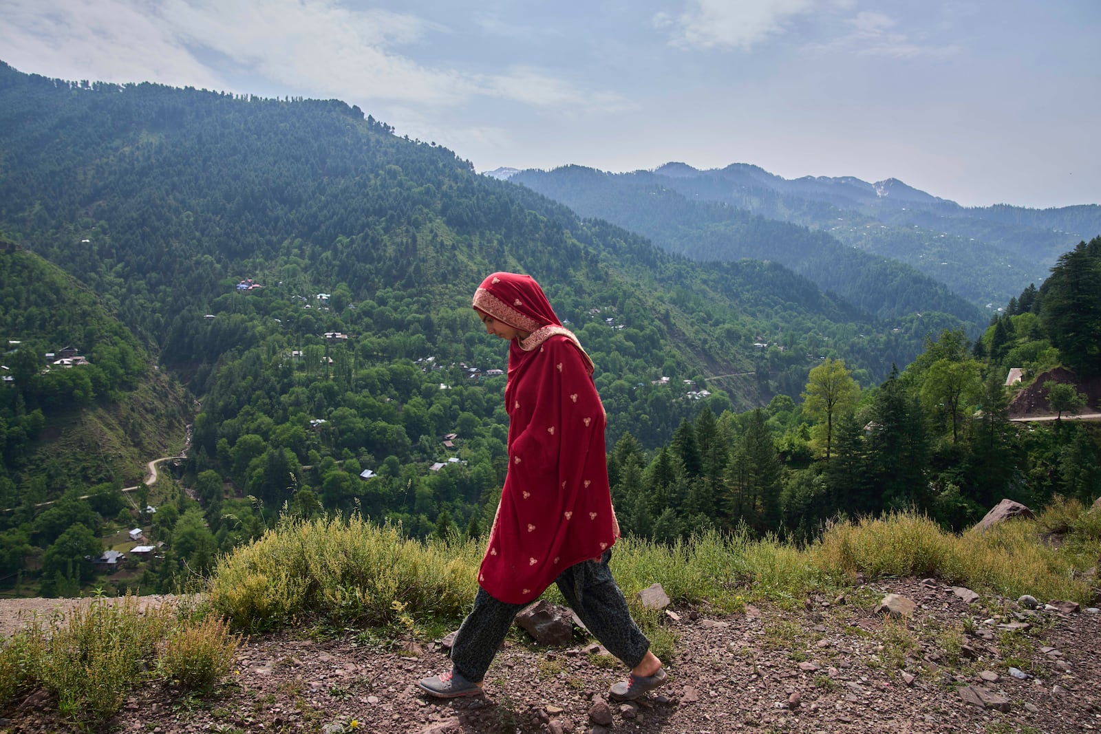 A Kashmiri villager woman walks towards her home at Tilawari village, near the Line of Control, north of Srinagar, Indian controlled Kashmir, Friday, May 2, 2025. (AP Photo/Dar Yasin)