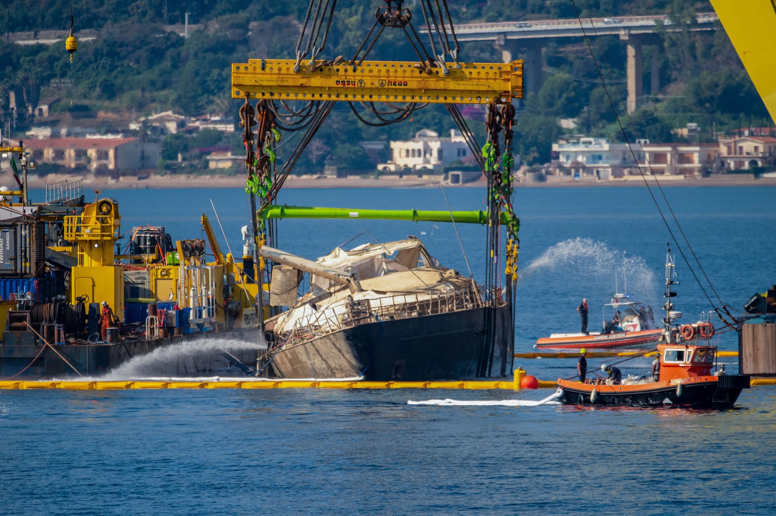 The hull of the superyacht Bayesian, which sank near Palermo, Sicily, on August 19, 2024, is pulled out of the sea and dewatered off the village of Porticello Saturday, June 21, 2025. (AP Photo/Salvatore Cavalli)