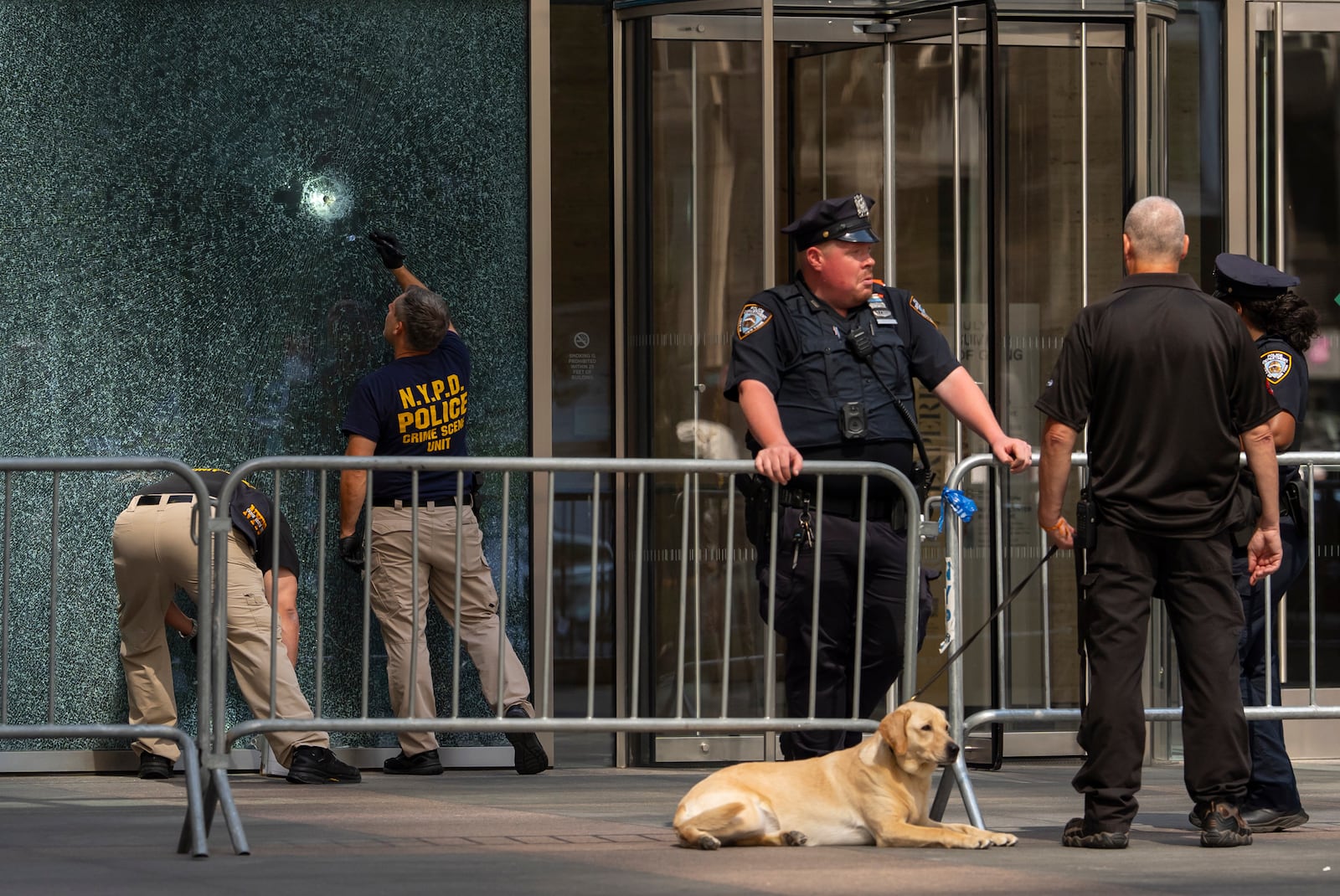 Members of NYPD Crime Unit examine a door with bullet holes at the scene of Monday's deadly shooting, Tuesday, July 29, 2025, in New York. (AP Photo/Yuki Iwamura)
